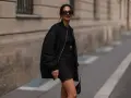 Stylische Frau in schwarzer Bomberjacke und engem Kleid. So kann man eine Bomberjacke kombinieren, Damen!