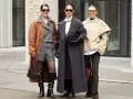 Drei Frauen präsentieren stilvolle Outfits im layering look: brauner Mantel über grauem Anzug, langer grauer Mantel und beiger Kurzmantel über weißem Hemd.