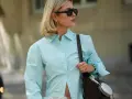 Stylische Frau mit Sonnenbrille und Schmuck, die eine hellblaue Bluse trägt. Ein Beispiel, wie man eine blaue Bluse kombinieren kann.