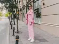 Eine Frau in einem auffälligen Outfit mit pinker Hose und passender Jacke. Ein modisches Statement, wie man pinke Hose kombinieren kann.