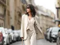 Eine Frau in einem beigen Leinenanzug, die lässig durch die Stadt geht. Die weite Leinenhose ist perfekt für den Sommer.