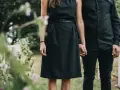 Frau in schwarzem Kleid und Mann in schwarzer Kleidung halten Händchen. So zieht man zur Beerdigung an als Frau.