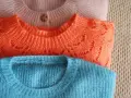 Gestapelte Pullover in Rosa, Orange und Blau. So kannst du deine **Wolle richtig waschen** und sie bleibt schön.