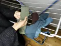 Hände sortieren frisch gewaschene, bunte Socken auf einem Wäscheständer.