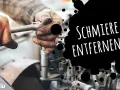 Hände mit Fettflecken reparieren ein Auto. Tipps, wie man Schmierfett aus Kleidung entfernen kann.