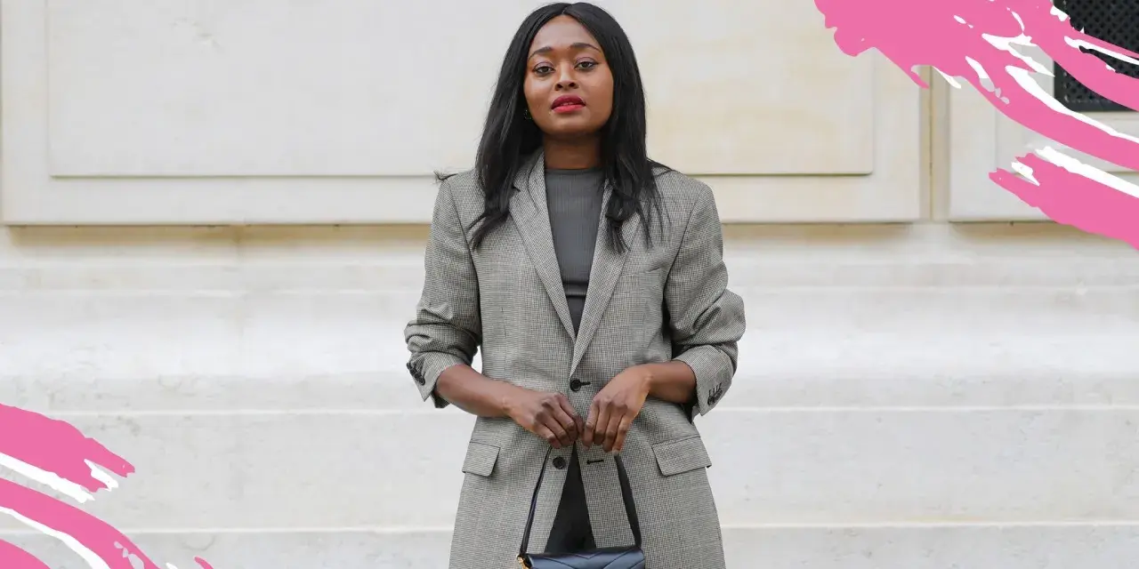 Eine Frau im karierten Blazer und schwarzer Tasche verkörpert einen schicken, lässigen Business-Look für Damen.