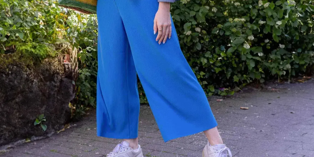 Blaues Culotte-Outfit mit Jeansjacke und bunten Tasche. So kann man Culottes kombinieren für einen lässigen Look.