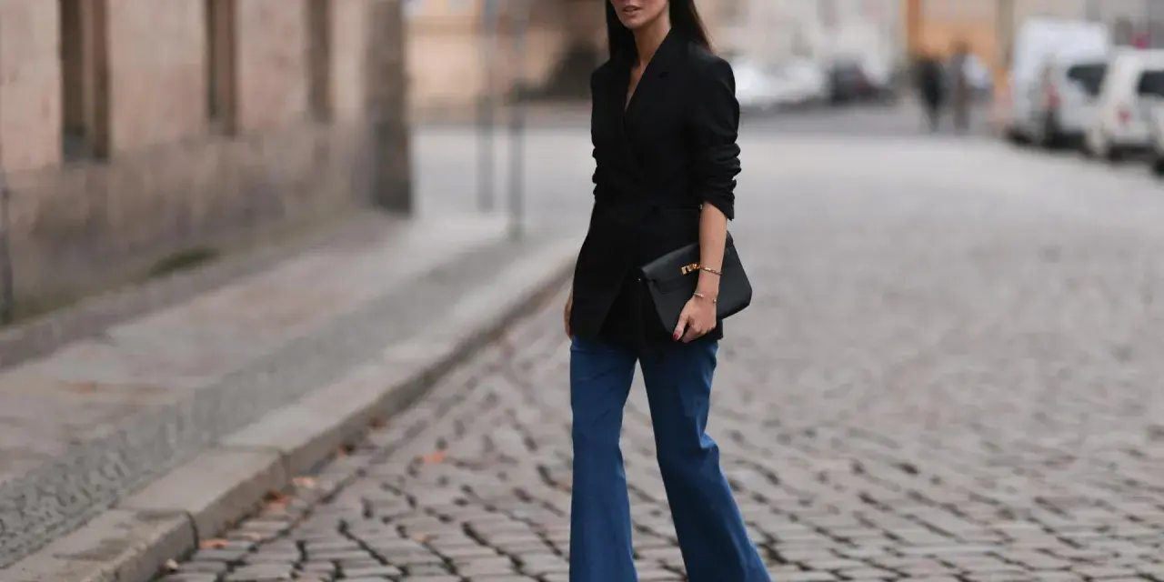 Stylische Frau in Schlaghosen und schwarzem Blazer. Ein tolles Beispiel, welche Oberteile zu Schlaghosen passen: elegant und modern.