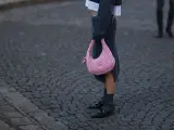 Ein grauer Strickrock kombiniert mit einem Oversize-Pullover und einer pinken Tasche.