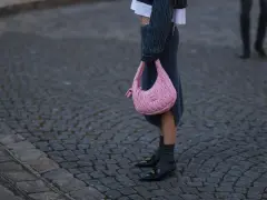 Ein grauer Strickrock kombiniert mit einem Oversize-Pullover und einer pinken Tasche.