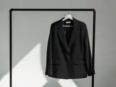 Schwarzer Blazer hängt auf einem Kleiderbügel. Zeit, den Blazer zu waschen und frisch zu machen.
