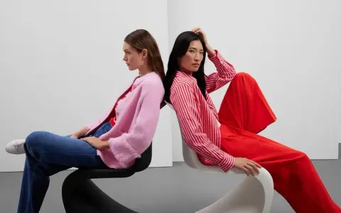 Zwei Frauen in leuchtenden Farben, ein Beispiel für Dopamin Dressing. Eine trägt einen pinken Cardigan, die andere ein rot-weiß gestreiftes Hemd und weite rote Hosen.