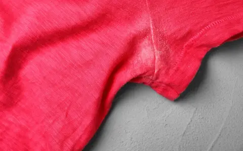 Rotes T-Shirt mit hartnäckigen Deo-Flecken unter dem Arm. Tipps zum Deoflecken entfernen gesucht.