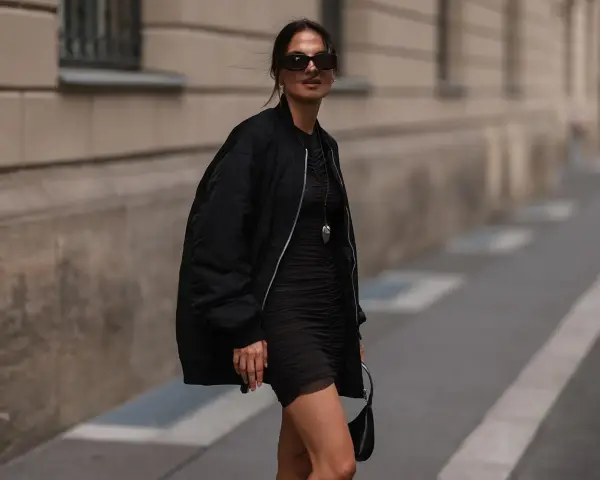 Stylische Frau in schwarzer Bomberjacke und engem Kleid. So kann man eine Bomberjacke kombinieren, Damen!