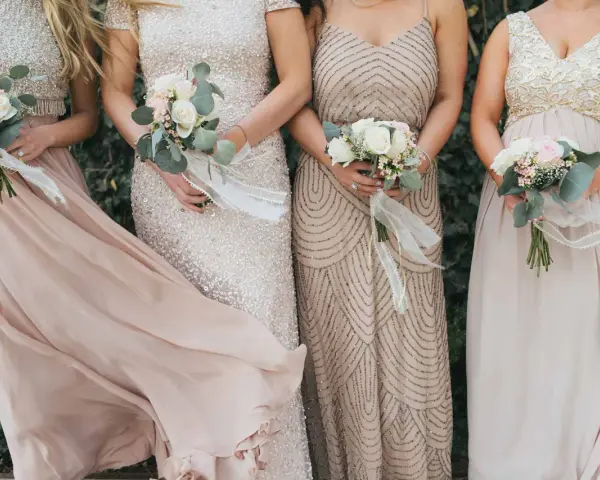 Brautjungfern in eleganten Kleidern mit Blumensträußen. Inspiration, was zieht man zur Hochzeit an als Gast Frau.