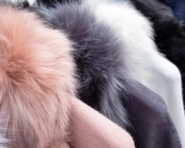 Weiche Kunstfell-Pompons in Rosa, Grau und Weiß. Ideal für Mützen, die man waschen kann.