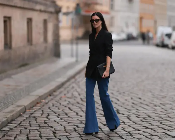 Stylische Frau in Schlaghosen und schwarzem Blazer. Ein tolles Beispiel, welche Oberteile zu Schlaghosen passen: elegant und modern.