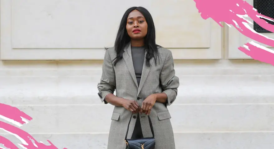 Eine Frau im karierten Blazer und schwarzer Tasche verkörpert einen schicken, lässigen Business-Look für Damen.