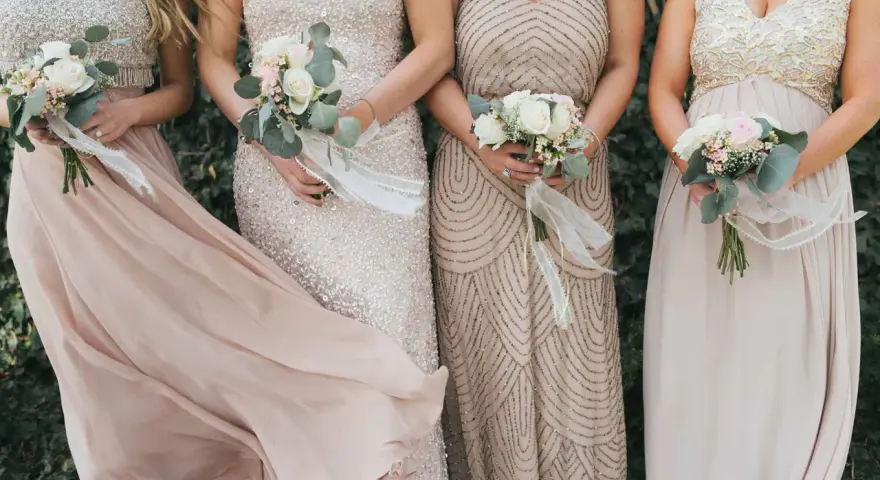 Brautjungfern in eleganten Kleidern mit Blumensträußen. Inspiration, was zieht man zur Hochzeit an als Gast Frau.