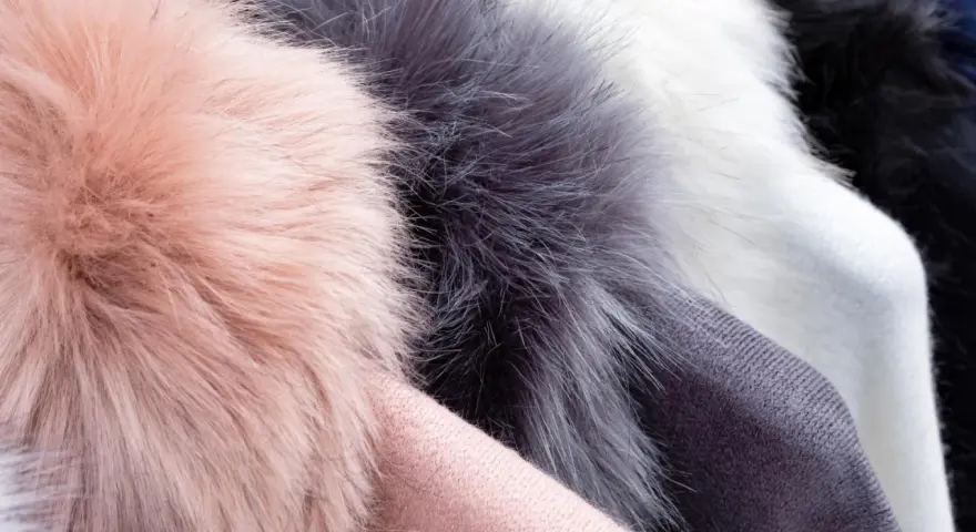 Weiche Kunstfell-Pompons in Rosa, Grau und Weiß. Ideal für Mützen, die man waschen kann.