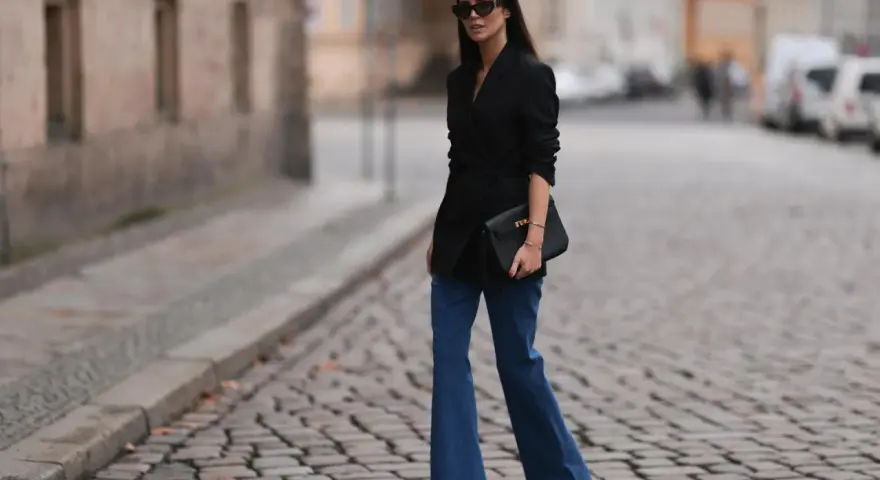 Stylische Frau in Schlaghosen und schwarzem Blazer. Ein tolles Beispiel, welche Oberteile zu Schlaghosen passen: elegant und modern.