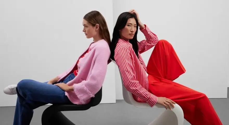 Zwei Frauen in leuchtenden Farben, ein Beispiel für Dopamin Dressing. Eine trägt einen pinken Cardigan, die andere ein rot-weiß gestreiftes Hemd und weite rote Hosen.