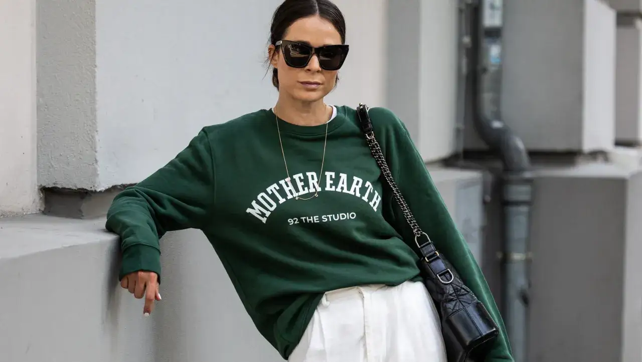 Frau mit Sonnenbrille und grünem Pullover mit 