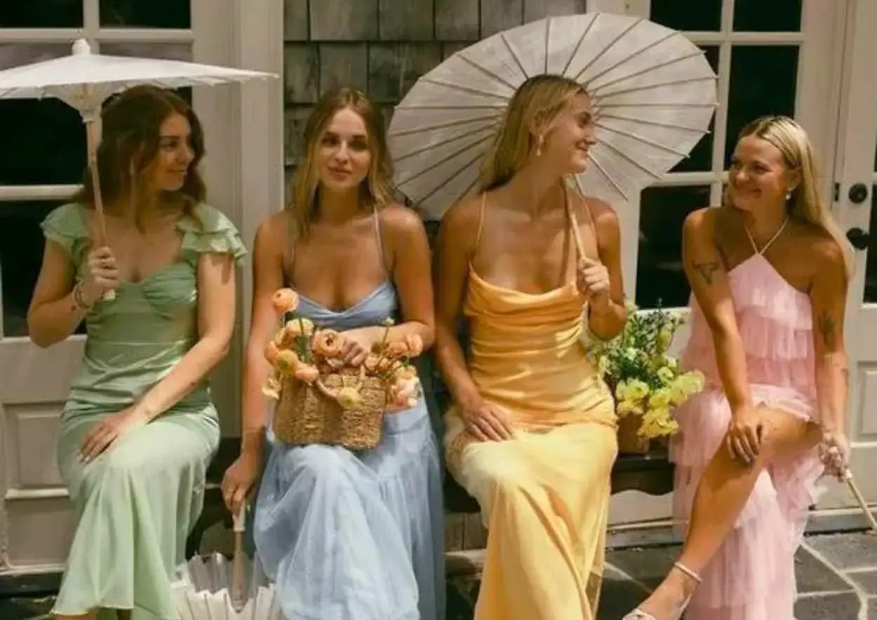 Vier Frauen in pastellfarbenen Kleidern, perfekt f&uuml;r eine Gartenparty im Sommer. Sonnenschirme und Blumenkorb runden den Look ab.