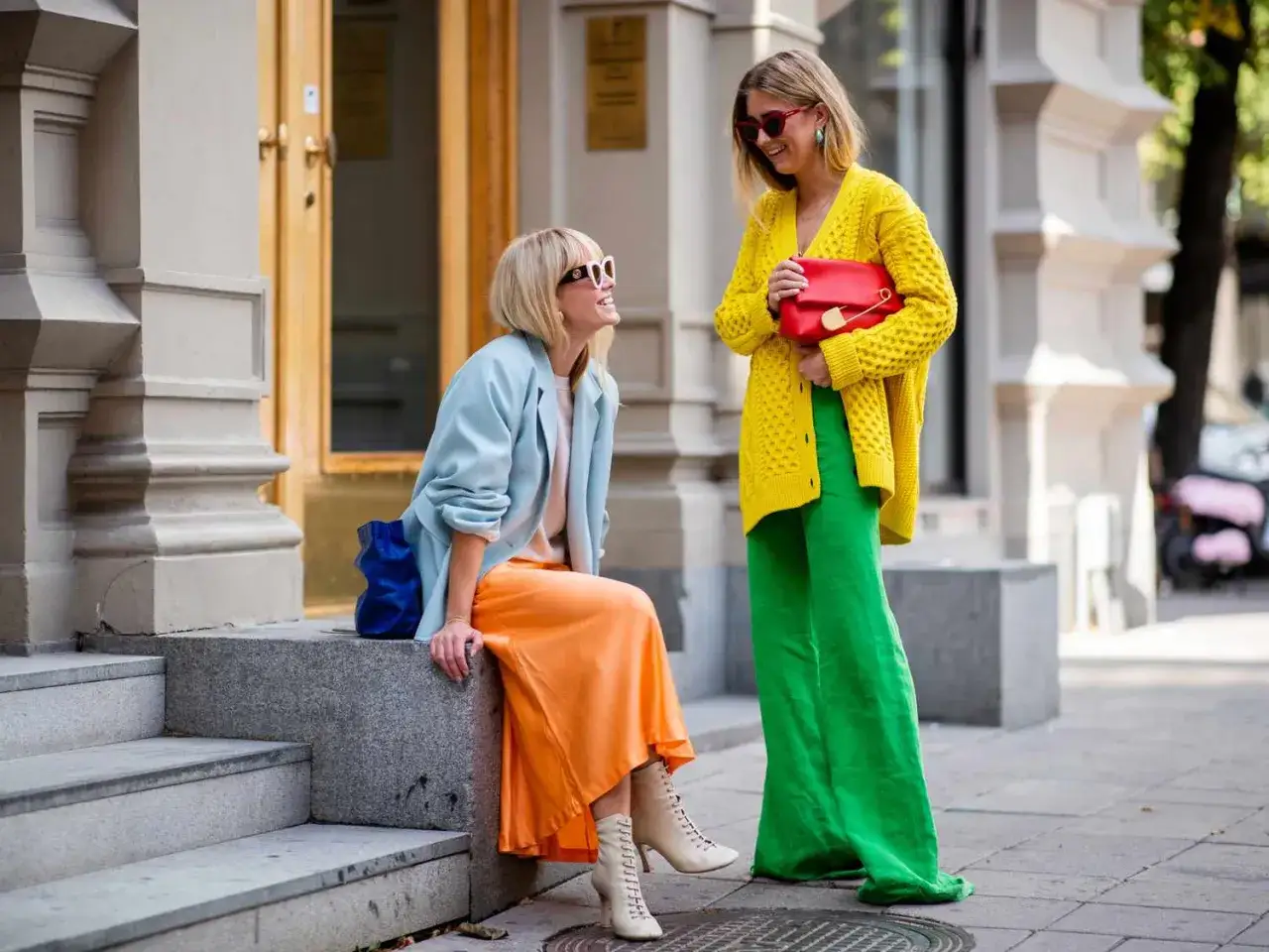 Zwei Frauen pr&auml;sentieren mutiges color blocking: eine in Pastellblau und Orange, die andere in leuchtendem Gelb und Gr&uuml;n.