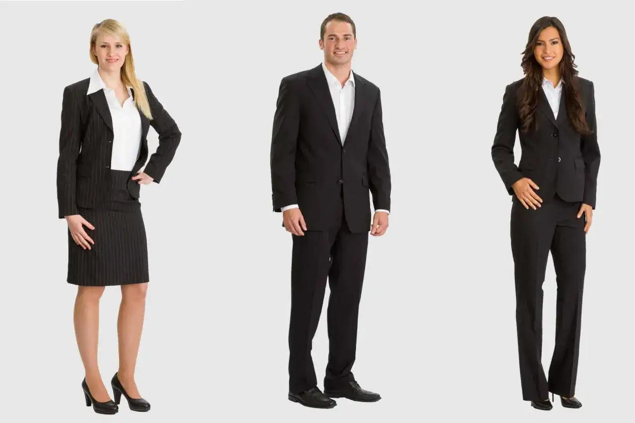 Drei Personen in eleganter Business-Kleidung: Frau im Nadelstreifen-Kost&uuml;m, Mann im schwarzen Anzug, Frau in schwarzer Hose und Blazer.