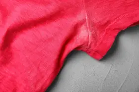 Rotes T-Shirt mit hartnäckigen Deo-Flecken unter dem Arm. Tipps zum Deoflecken entfernen gesucht.